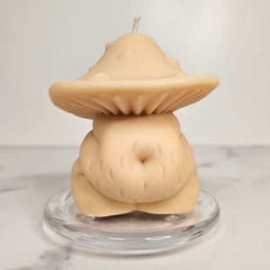 Mushroom-shaped candle on a clear stand with a white background